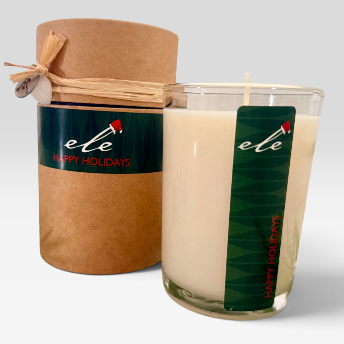 Happy Holidays 7 oz glass candle and gift tube on a clean light background
